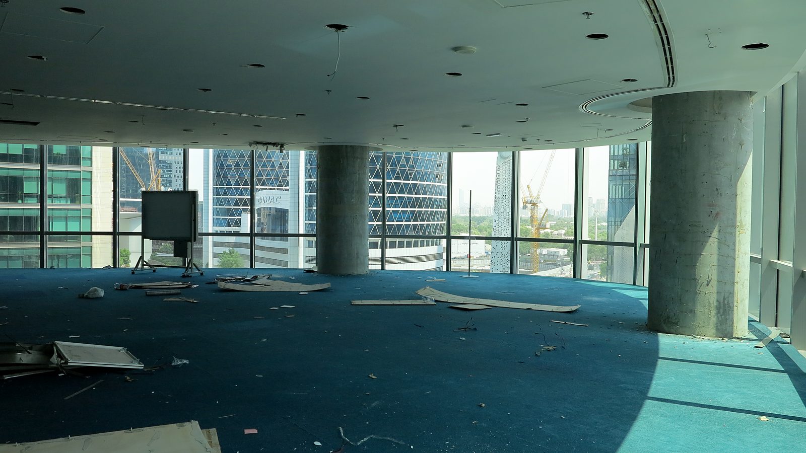 The open floor before works, with worn carpet and debris