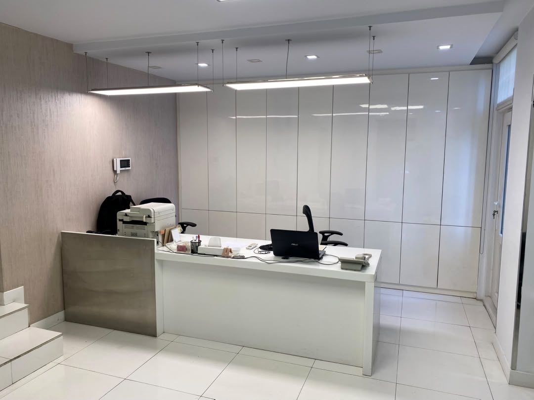 Reception desk in front of full-height gloss white storage