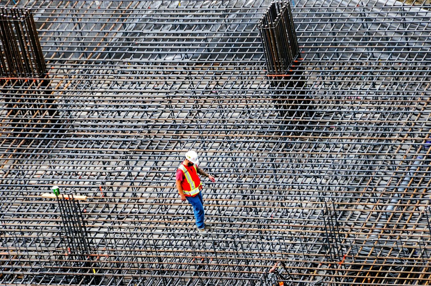 Engineer walking a reinforced raft foundation mat with column starter bars