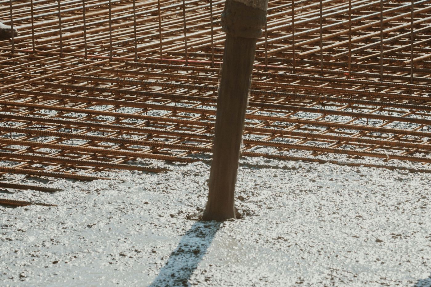 Concrete pumped through a hose into a reinforced slab during a pour